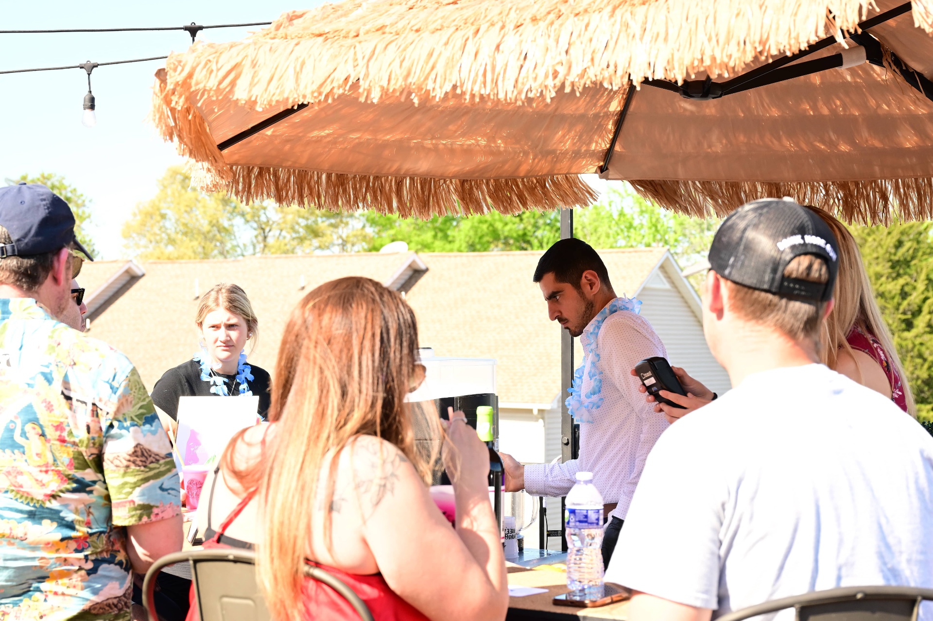 Bartender serving guests under the tiki umbrella